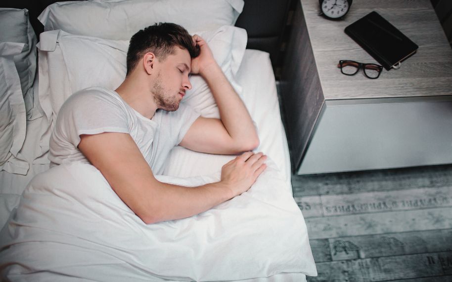 El descanso puede ayudar a mejorar los síntomas de la psoriasis El descanso puede ayudar a mejorar los síntomas de psoriasis: hombre joven durmiendo en su cama.