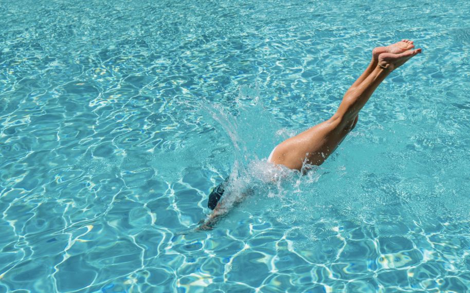 Persona con psoriasis nadando en piscina
