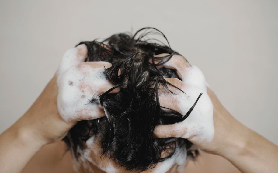 Tratamientos para la psoriasis del cuero cabelludo Champús y tratamientos para la psoriasis capilar: persona lavándose la cabeza
